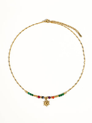 Gold necklace with colorful beads on a white background