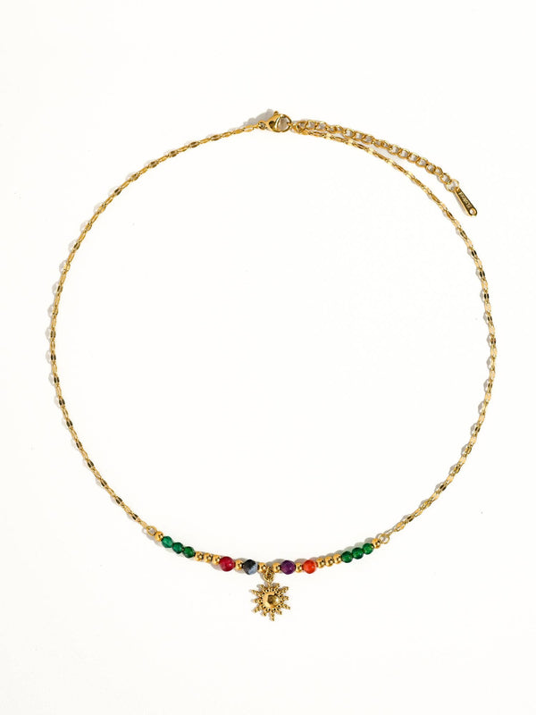 Gold necklace with colorful beads on a white background