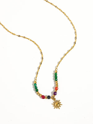 Necklace with colorful beads and a gold sun pendant on a white background