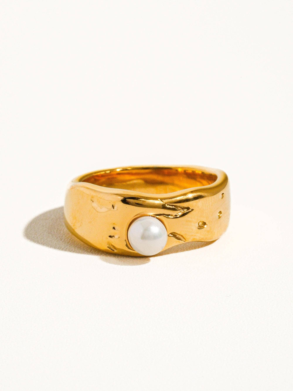 Gold ring with a pearl on a white background