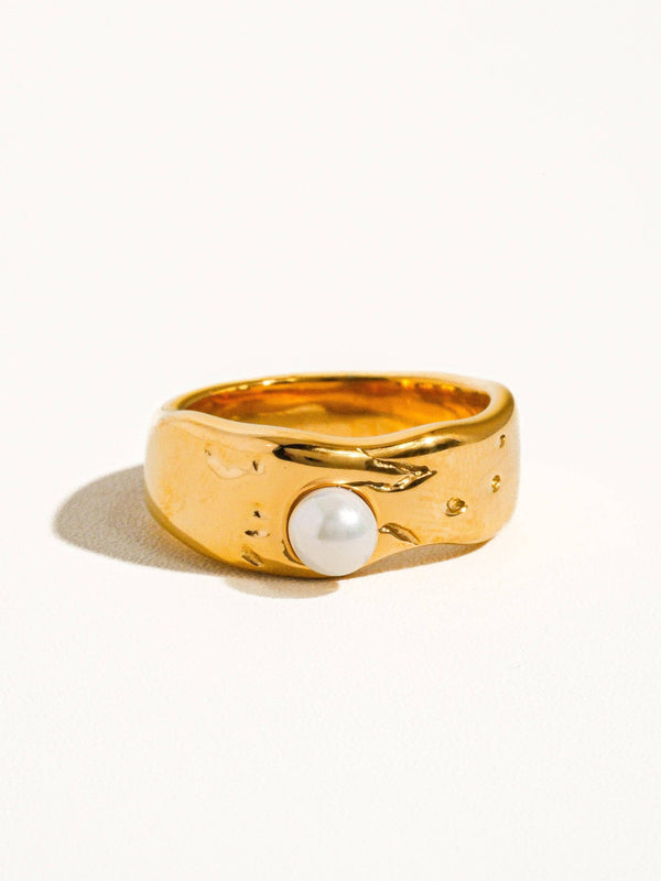 Gold ring with a pearl on a white background