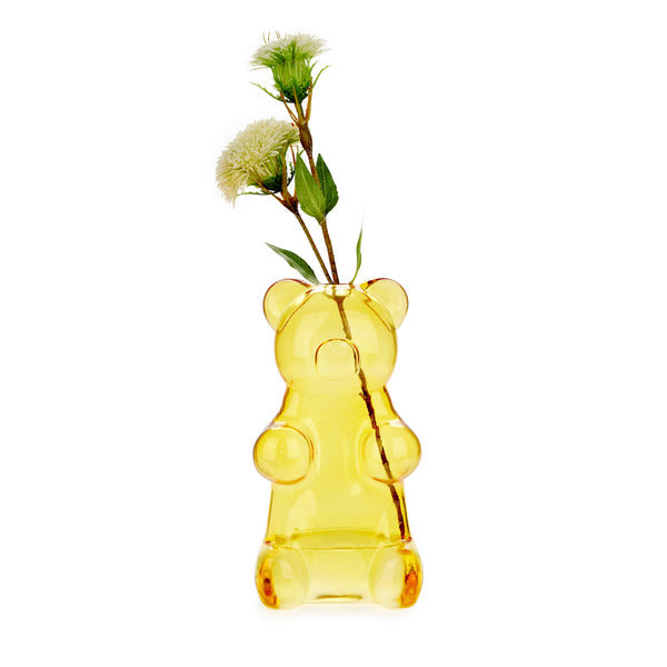 Yellow bear-shaped vase with a plant on a white background