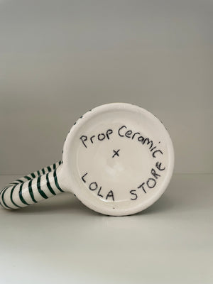 Ceramic prop with striped handle and 'Lola Store' branding on a gray background