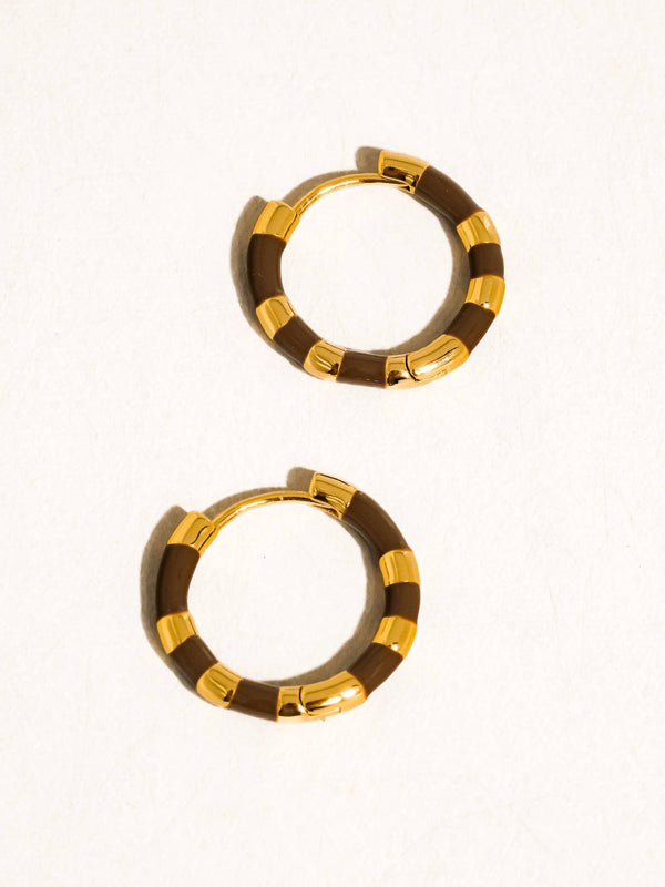 Pair of gold and brown hoop earrings on a white background