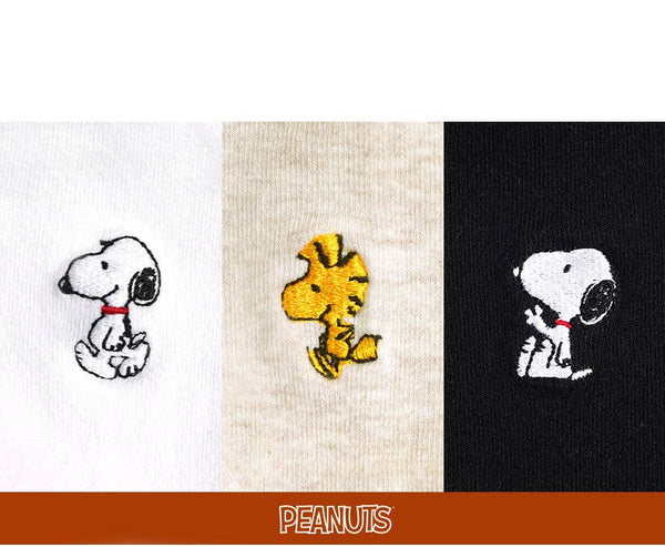 Three embroidered designs of Snoopy, Woodstock, and another dog on different fabric backgrounds with 'Peanuts' branding.