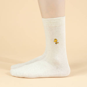 White sock with a small yellow flower Woodstock Snoopy design on a beige background