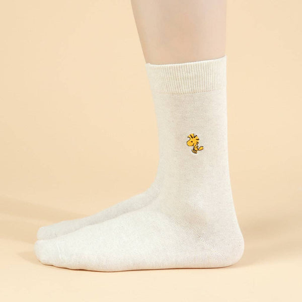 White sock with a small yellow flower Woodstock Snoopy design on a beige background